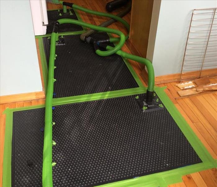 The hardwood floors have the drying mat system being used to dry the hardwood floors